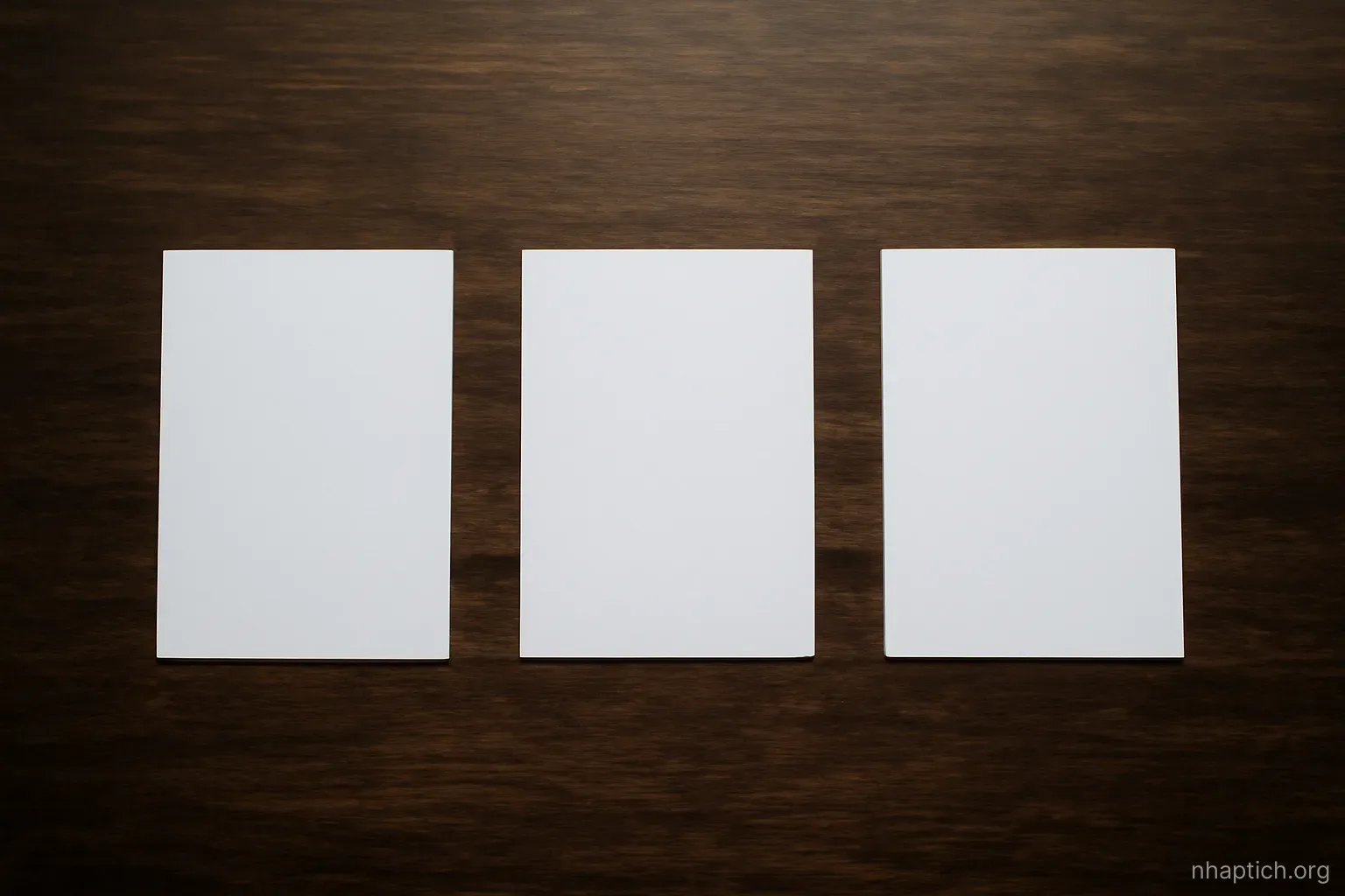 three blank index cards laid out in a row on a dark wooden table, evenly spaced, top-down view